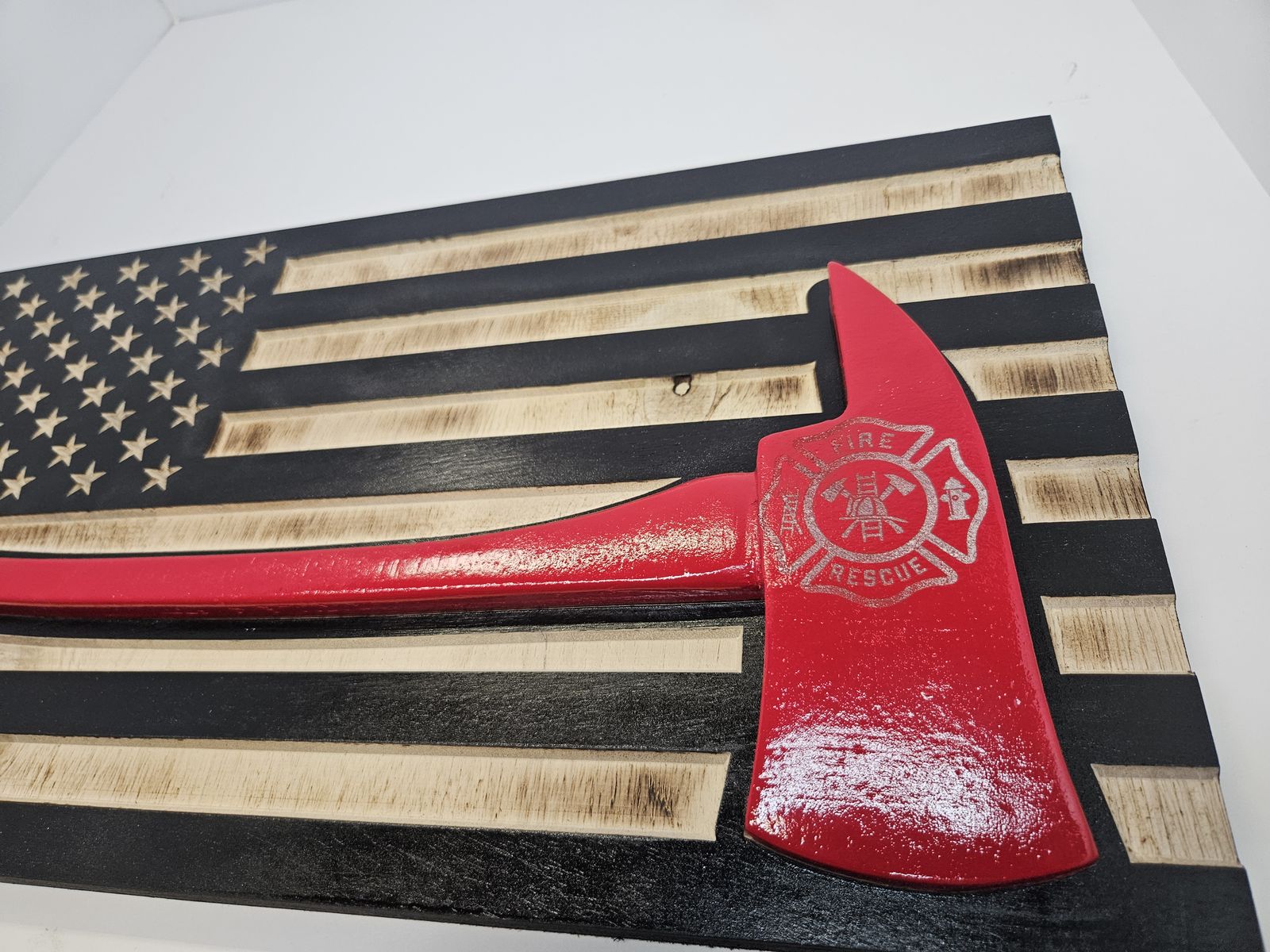 Firefighter flag close-up showing the engraved Maltese cross on the axe head